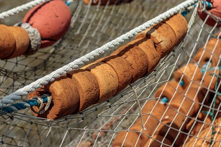 vintage bouy on fishing net set out on wooden dock