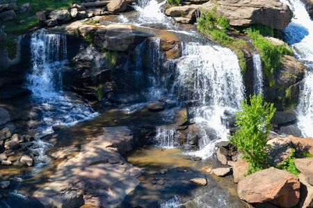 small waterfall flowing down a rockface in the forest