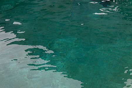 blue teal water with ripples in a pool in indoor light
