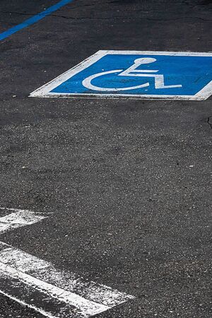 painted symol of handicap parking only sign in blue and white on asphaltの写真素材