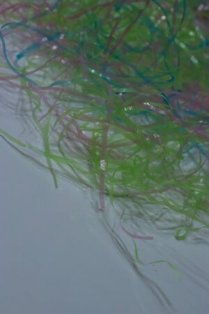 colored plastic easter grass on a white background in spring