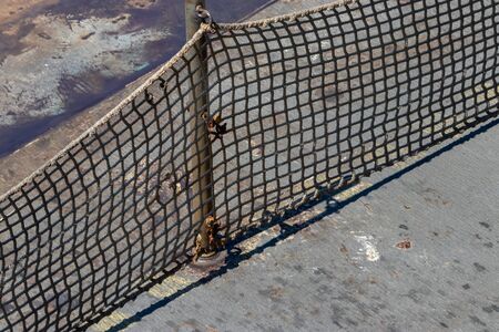 safety net on ship protecting people from the ocean water flowing by on sunny day