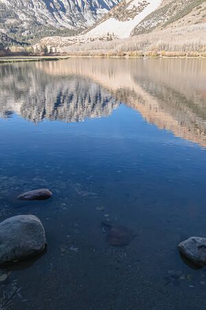 bright blue water reflects mountains in morning glow at sunrise