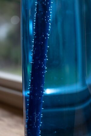 air bubbles in water in a blue water bottle with a blurred backgroundの写真素材