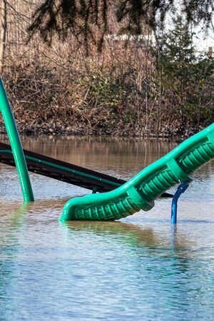 a playground slide in a flooded parkの写真素材