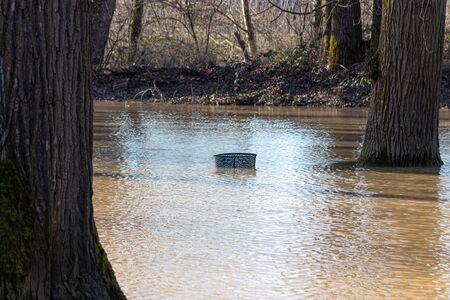 top rim of trash can in flooded park