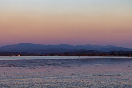 Serene Ocean Sunset with Distant Mountains