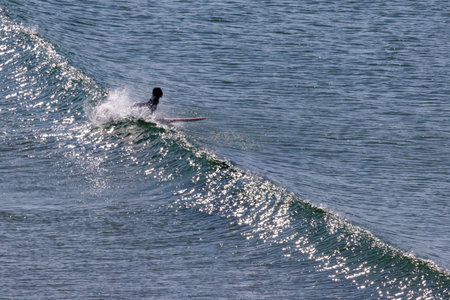 Surfer catching a wave on a sunny ocean dayの写真素材