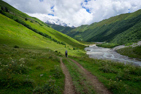 Svaneti views, hiking trail through green mountains, snow-capped peaks, mountain riversの写真素材