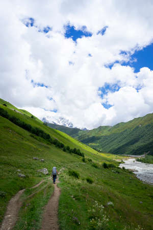 Svaneti views, hiking trail through green mountains, snow-capped peaks, mountain riversの写真素材