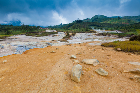 Smoke of Sulfur Mud Volcano Geyser on Plateau Dieng National Park, Java, Indonesiaの写真素材