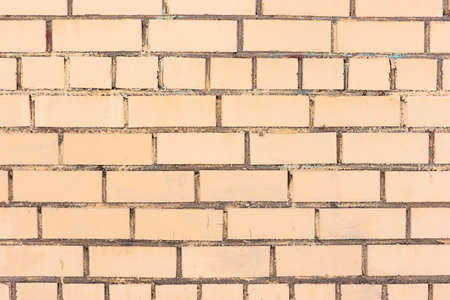 Yellow brickwork background. Brick wall painted with yellow paint.の写真素材