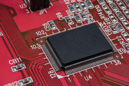 Detail of red electronic board. Close-up of electronic circuit board with SMD components and chipの写真素材
