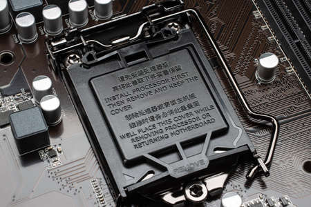 Close-up of the slot for installing the processor closed with a plastic protective cap. Modern motherboard before installing the processor.の写真素材