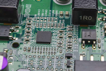 Details of electronic board. Close-up of electronic circuit board with SMD components, microcircuits, capacitors and chipsの写真素材