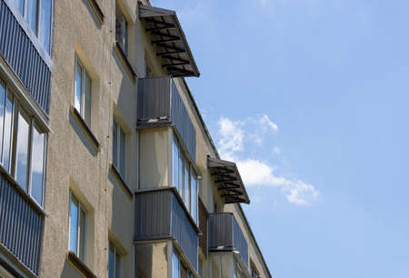 Close-up of the facade of an old apartment building with balconies against the blue skyの写真素材