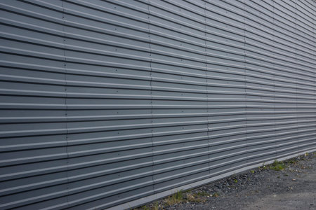 Large flat wall sheathed with gray metal roof sheets