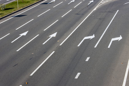 Close-up view of a section of a multi-lane freeway and its exit. Road markings with white paint on asphalt.の写真素材