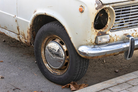 Close-up of an old rusty vintage car without headlights from the USSR abandoned on the streetの写真素材