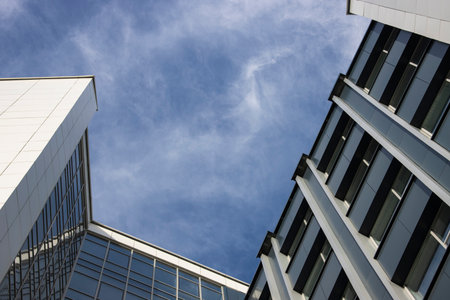 Bottom view of a beautiful tall modern office building against the skyの写真素材