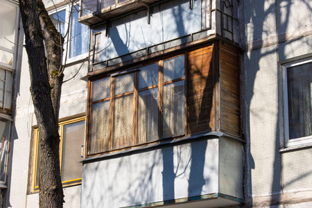 Close-up of an old dilapidated balcony lined with wood in an old soviet apartment buildingの写真素材