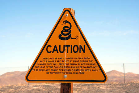 Sign that warns people about the danger of rattlesnakes in the area.の写真素材