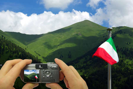 Photo montage of a tourist taking a photo of the mountains in Italy.の写真素材