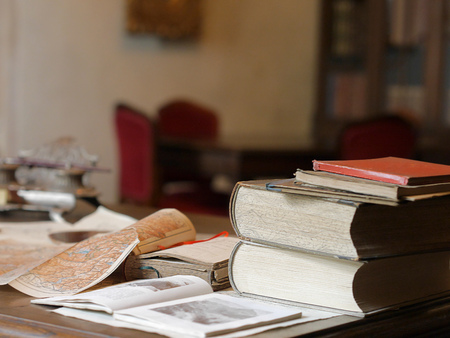 Old books and maps on wooden table.の写真素材