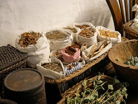 Variety of dried herbs in sacks and wicker baskets.の写真素材