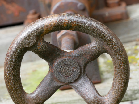 Old tightening screw. Vintage machinery details closeup. Rusty gear wheels.