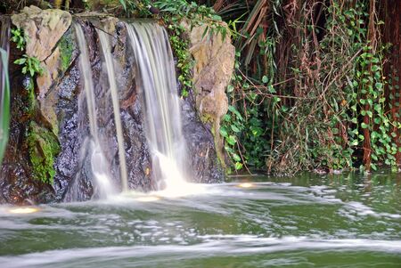 Small waterfall flowing into a small lake の写真素材