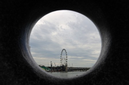 Singapore, August, 29, 2010 - Singapore Flyer through a round hole in a stone.のeditorial素材