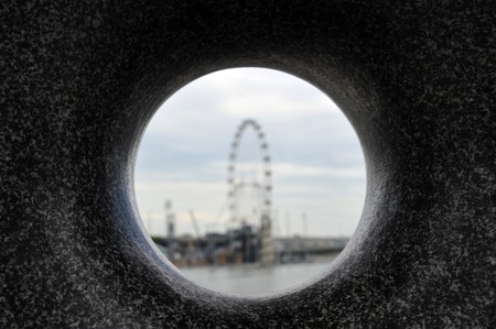 Singapore, August, 29, 2010 - Singapore Flyer through a round hole in a stone.のeditorial素材