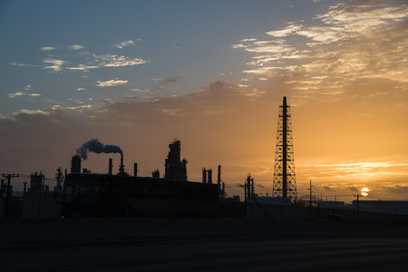 Silhouette oil refinery at sunrise. Oil factory, petrochemical plant tower, gas flare, smoke stacks and machinery in Corpus Christi, Texas, USA. Petroleum industry background.の写真素材