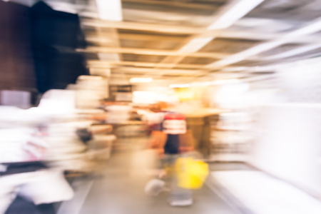 Blurred image furniture store with variety of carpets and floor coverings for sell. Customers shopping for carpets at appliances and home accessories interior store in America. Abstract vintage toneの写真素材
