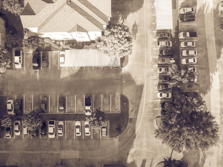 Vintage tone aerial view of apartment garage with full of covered parking, cars and green trees of...