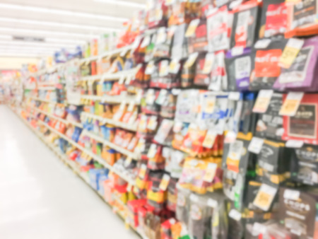 Blurred snack time, candy, chips, cookies, crackers, popcorn, nuts, rice cakes at retail store in America. Defocused snack time treats aisle on display with price tags at department.の写真素材