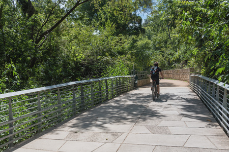 Back view man biking along nature boardwalk near downtown Austinの写真素材