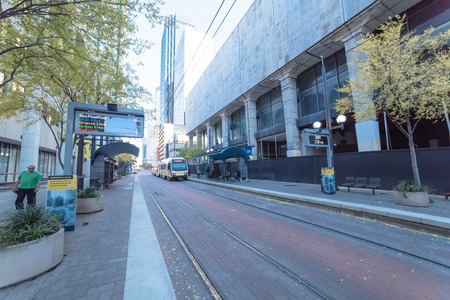 Light rail train station with passenger waiting in downtown Dallのeditorial素材