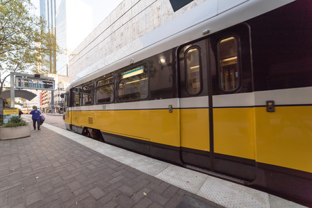 Yellow light rail train at station in downtown Dallasのeditorial素材