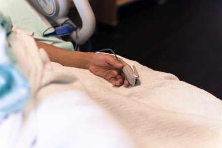 Filtered image woman hand with pulse oximeter and heart rate finの写真素材