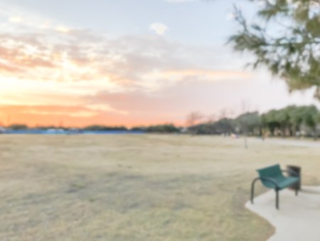 Blurry background sunset at city park with bench in suburban Dalの写真素材