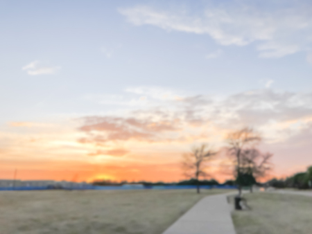 Blurry background sunset at city park with bench in suburban Dalの写真素材