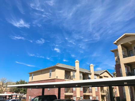 New apartment complex with covered parking under sunny cloud sky in Texasの写真素材
