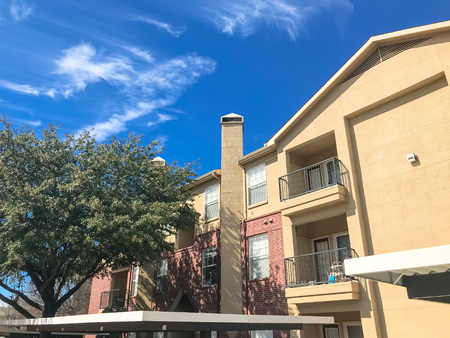New apartment complex with covered parking under sunny cloud sky in Texasの写真素材