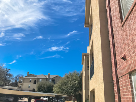 New apartment complex with covered parking under sunny cloud sky in Texasの写真素材