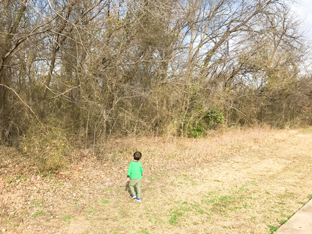 Healthy Asian boy walking on natural trail in wintertimeの写真素材