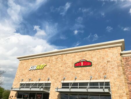 Facade entrance to Papa Johns American pizza restaurant chain blue skyのeditorial素材