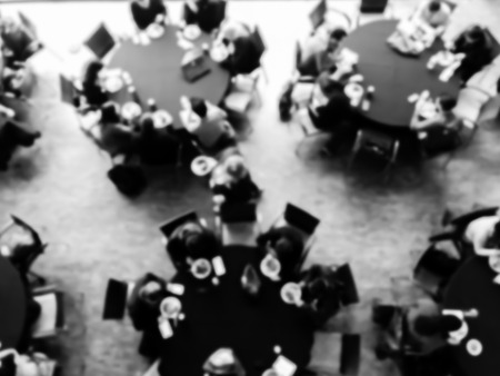 Vintage tone blurred top view lunch break at conference meeting. Defocused delegates networking on...