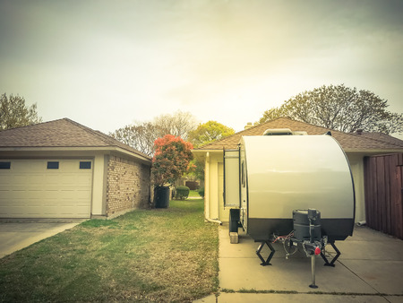 Rear view of RV trailer parked at house garage backyard